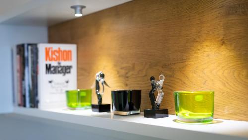 a shelf with three green cups and books on it at Lake View Apartment in St. Wolfgang