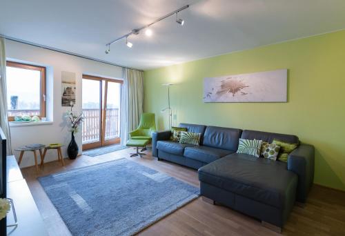 a living room with a blue couch and a green wall at Lake View Apartment in St. Wolfgang