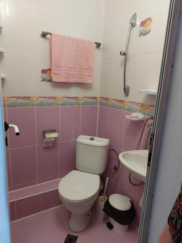 a pink bathroom with a toilet and a sink at Guest House Neli in Nesebar