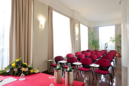 a conference room with red chairs and a table at Hotel San Pietro in Verona