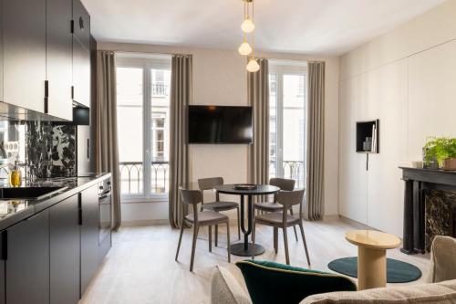 une cuisine et un salon avec une table et des chaises dans l'établissement Yuna Saint-Honoré - Serviced Apartments, à Paris