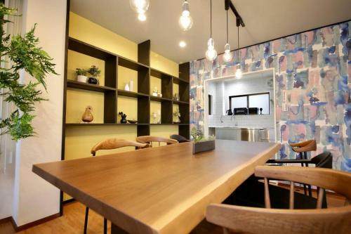 a dining room with a wooden table and chairs at Pufuka Inn Skytree in Tokyo
