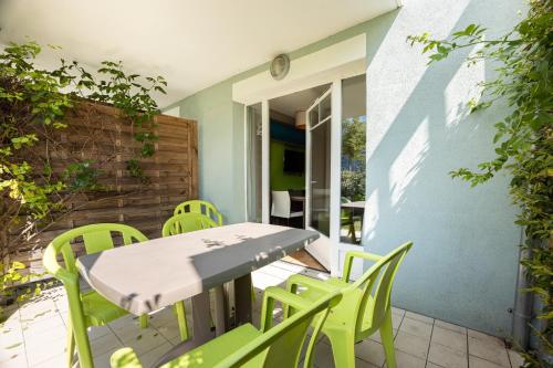 un patio avec une table et des chaises sur un patio dans l'établissement Océanite, à Courseulles-sur-Mer