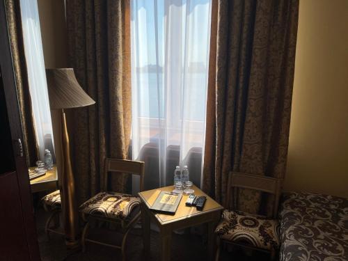 a hotel room with two chairs and a window at Отель Фараон in Kyiv
