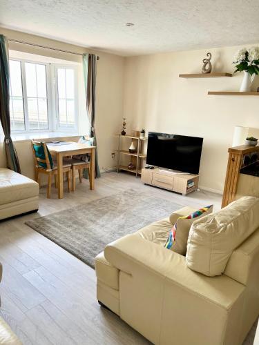 a living room with a white couch and a table at Campbell Apartment in Cardiff