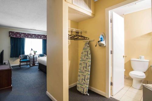 a bathroom with a toilet and a bedroom at Econo Lodge Inn & Suites in Tilton