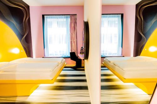 a room with two beds and two windows at Prize by Radisson, Bonn City in Bonn