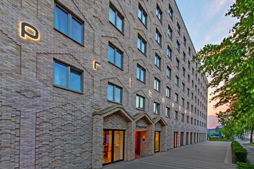 a brick building with red doors on a street at Prize by Radisson, Hamburg City in Hamburg