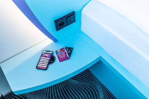 a cell phone and a book sitting on a table at Prize by Radisson, Rostock City in Rostock