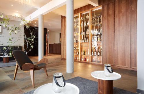 una habitación con 2 mesas y una estantería de botellas de vino en Best Western Plus Atrium Hotel, en Ulm