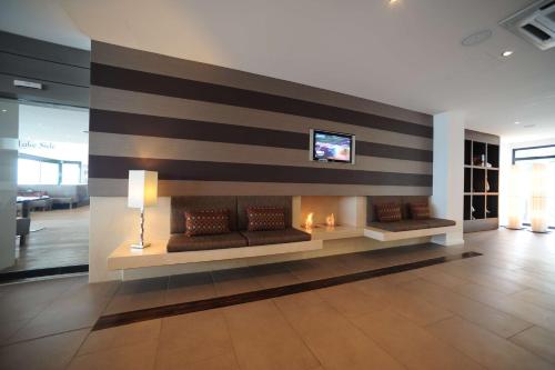 ヌーシャテルにあるベスト ウェスタン プレミア ホテル ボーラックのソファと壁掛けテレビ付きのロビー