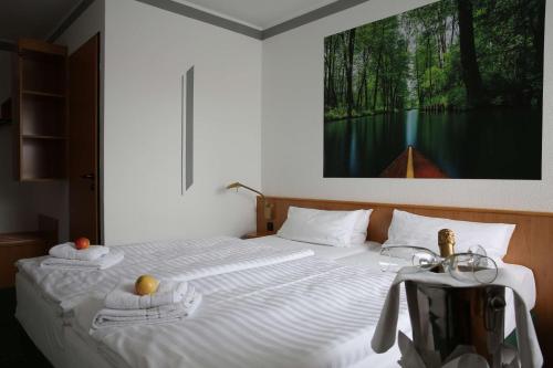 um quarto com uma cama com toalhas e um quadro na parede em Best Western Spreewald em Lübbenau