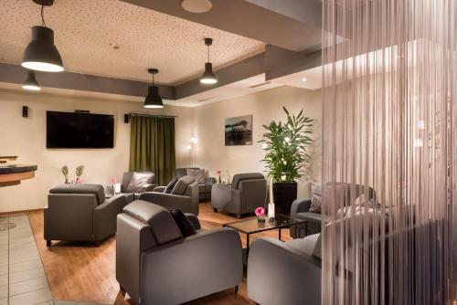 poczekalnia z kanapami i krzesłami oraz telewizorem w obiekcie Best Western Hotel Dortmund Airport w Dortmundzie
