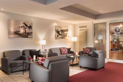 a waiting room with couches and chairs and tables at Best Western Hotel Dortmund Airport in Dortmund
