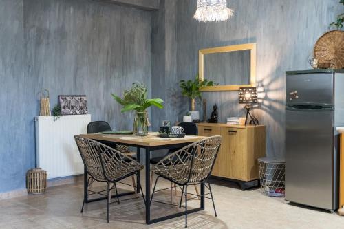 a dining room with a table with chairs and a refrigerator at Armiriki in Lixouri