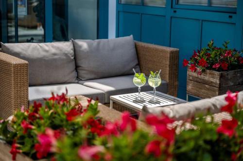 um sofá e uma mesa com dois copos de vinho em Best Western Plus Hotel Erb em Parsdorf