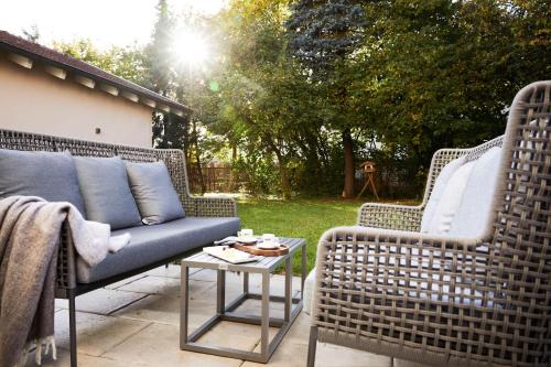 2 Korbstühle und ein Tisch auf einer Terrasse in der Unterkunft Best Western Plus Hotel Erb in Parsdorf
