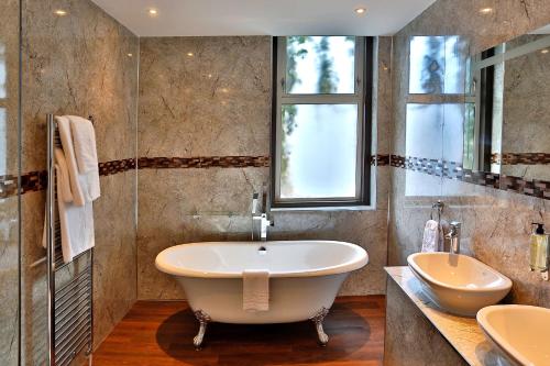 baño con bañera grande y lavamanos en Best Western Plus The Connaught Hotel and Spa en Bournemouth