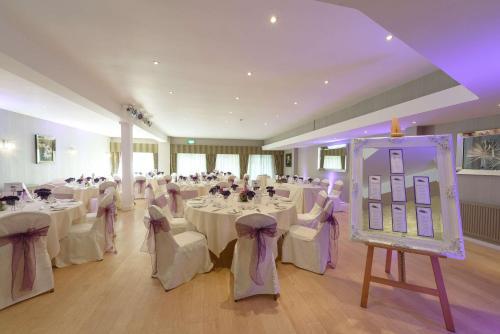 a banquet hall with tables and chairs and a stage at Best Western Plus The Connaught Hotel and Spa in Bournemouth