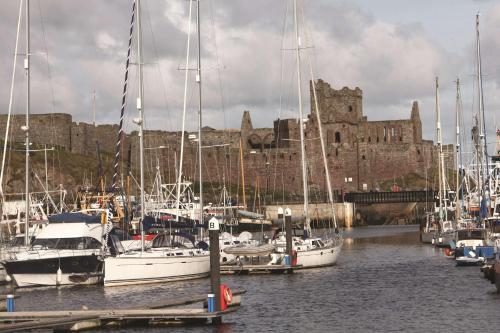 a group of boats docked in a harbor with a castle at Best Western Palace Hotel & Casino in Douglas
