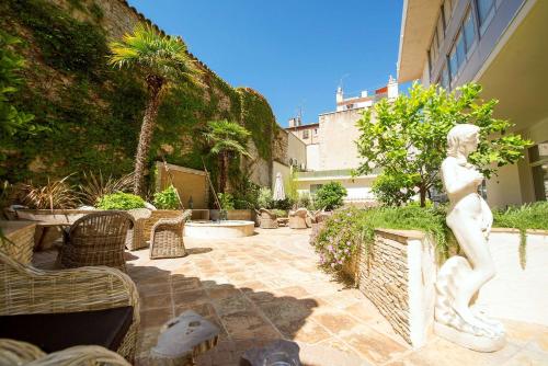 a statue of a woman standing in a courtyard at Best Western Premier Le Patio des Artistes Wellness Jacuzzi in Cannes