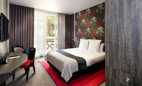 a hotel room with a bed and a desk at Best Western Premier Le Patio des Artistes Wellness Jacuzzi in Cannes