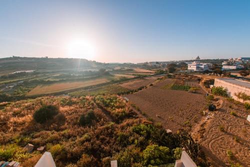 a view of a field with the sun in the background at City Stay B&B in Taʼ l-Imgħajjen