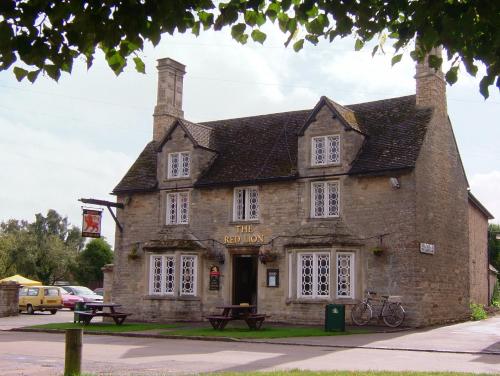 an old stone building with a bike parked in front at Cottage on the Green in Brackley