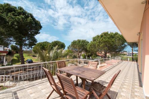 a wooden table and chairs on a balcony with trees at Southgate Apartments in Agios Georgios