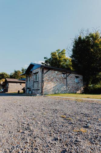 a brick house sitting on top of a gravel road at OPG Dokić in Kopačevo