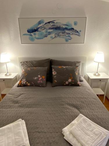 a bedroom with a bed with pillows and two lamps at Apartments Kosljun 123 in Košljun