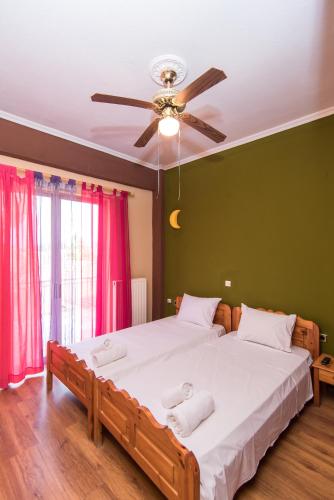 a bedroom with a large bed with a ceiling fan at Southgate Apartments in Agios Georgios
