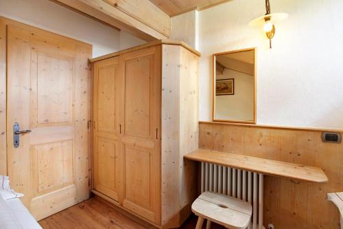Habitación con armario de madera y espejo. en Appartamento Castagno Chalet Cambra, en Livigno