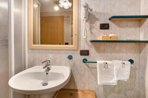 W łazience znajduje się umywalka, lustro i ręczniki. w obiekcie Appartamento Larice Chalet Cambra w Livigno