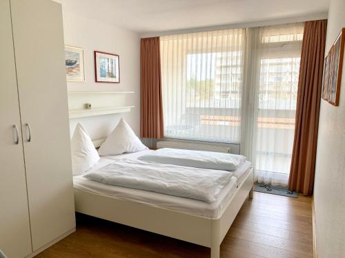 un letto in una camera con una grande finestra di Feierabend-Koje im Haus Villa Anna a Sankt Peter-Ording
