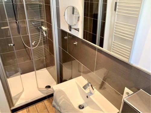 bagno con lavandino e doccia con specchio di Ferienwohnung "Fuchsbau" a Sankt Peter-Ording