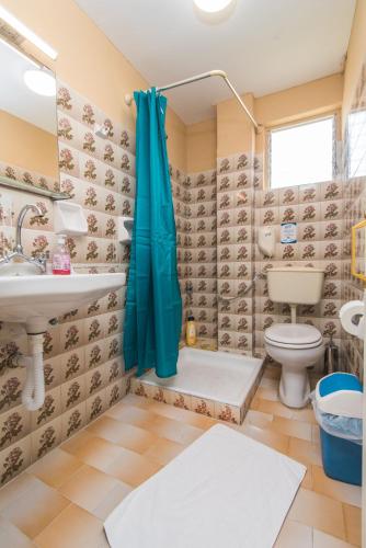 a bathroom with a toilet and a sink and a shower at Southgate Apartments in Agios Georgios