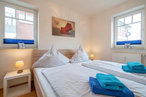 um quarto com 2 camas e 2 janelas em Ferienwohnung "Böhler Strandperle" em Sankt Peter-Ording