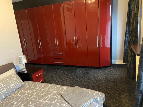 a bedroom with red cabinets and a bed at St Pauls Rd - Townhouse Accommodation in Bradford