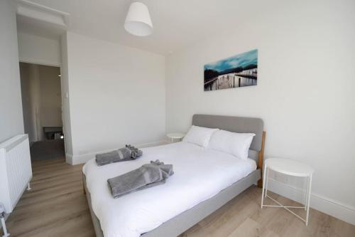 a bedroom with a white bed and a table at Spacious Holiday Home in Porthcawl in Porthcawl