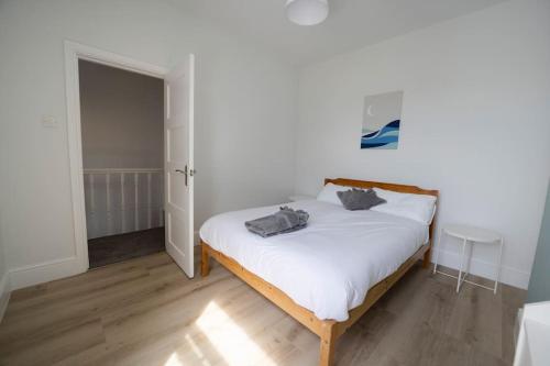 sypialnia z białym łóżkiem z 2 poduszkami w obiekcie Spacious Holiday Home in Porthcawl w mieście Porthcawl