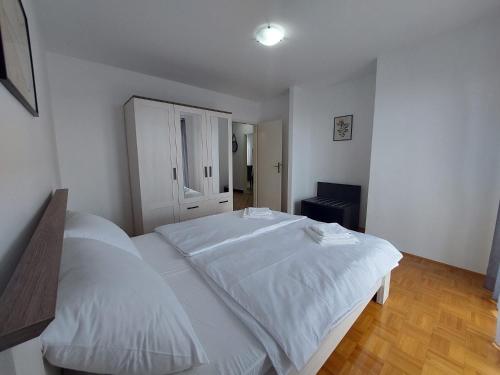 - une chambre avec un lit blanc et une armoire dans l'établissement Violeta, à Crikvenica