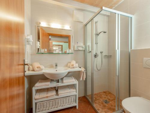 ein Bad mit einem Waschbecken und einer Dusche in der Unterkunft Familienhotel Unterreith in Forstau