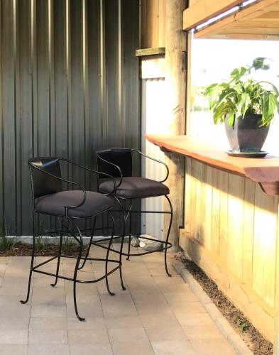 a couple of chairs sitting at a bar at Cosy Country Stay B&B in Matamata