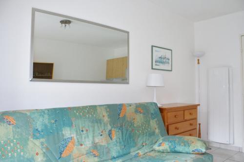 un salon avec un canapé bleu et un miroir dans l'établissement Terrasse de La Baule - DEUX, à La Baule