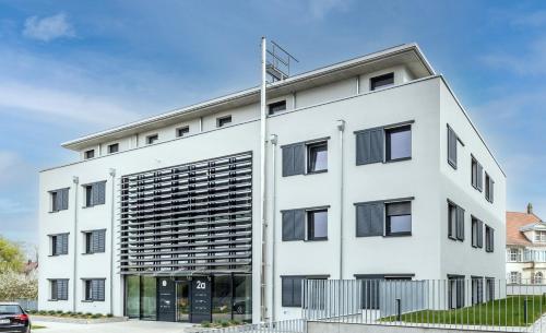 an image of a white building with black shutters at Penthouse Ferienwohnung in Bahlingen