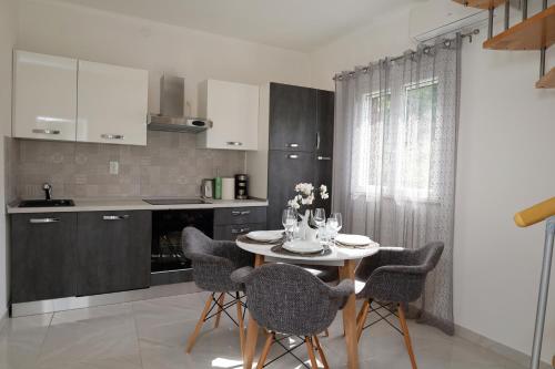 a kitchen with a table and chairs in a kitchen at Holiday house Nono in Sumartin