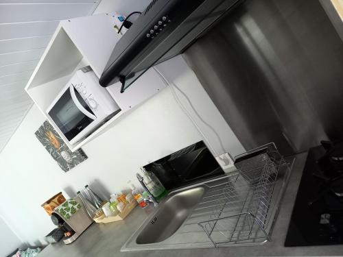 a kitchen with a sink and a microwave at Rava Lodge in Punaauia