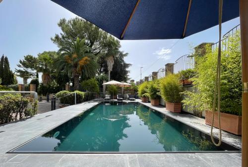 uma piscina com um guarda-sol num edifício em Hotel Casal Dell'Angelo em Marigliano