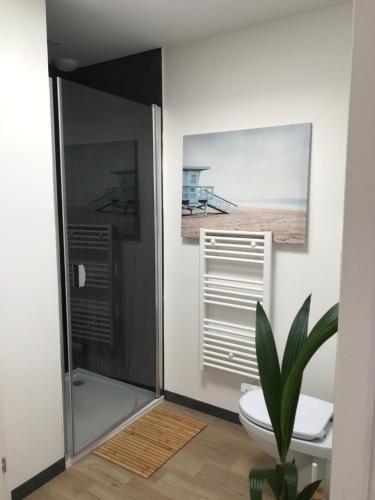 a bathroom with a toilet and a picture of the beach at Maison de Vacances 2 personnes, ossature bois, à Saint Gilles Croix De Vie 85 in Saint-Gilles-Croix-de-Vie